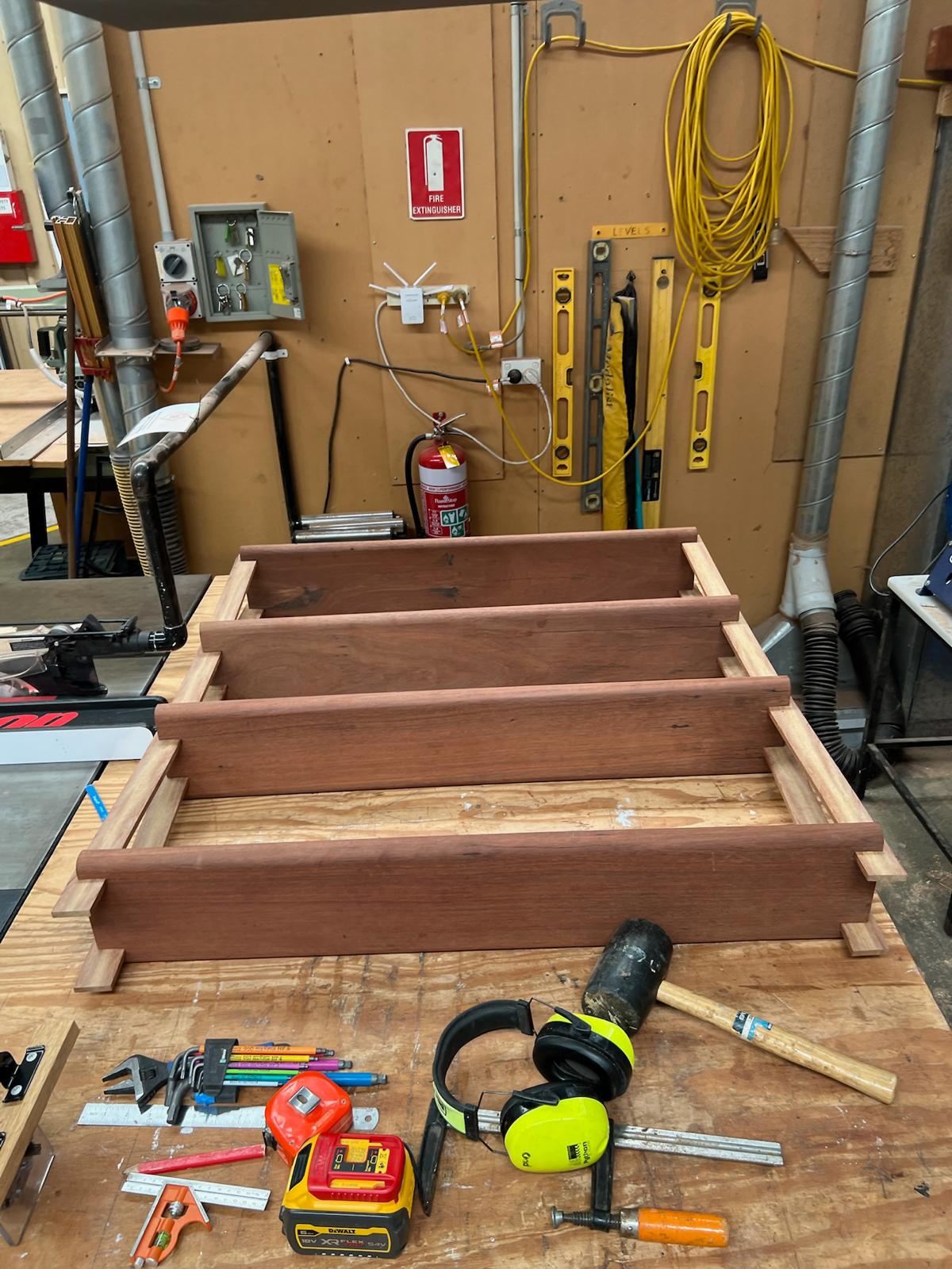 Jarrah shelf frame dry-assembled on the bench with mallet, squares and clamps to hand